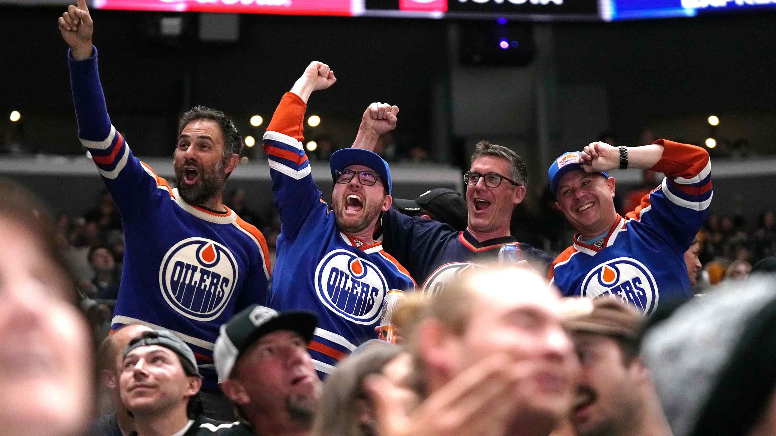 A photo of Oilers fans cheering.
